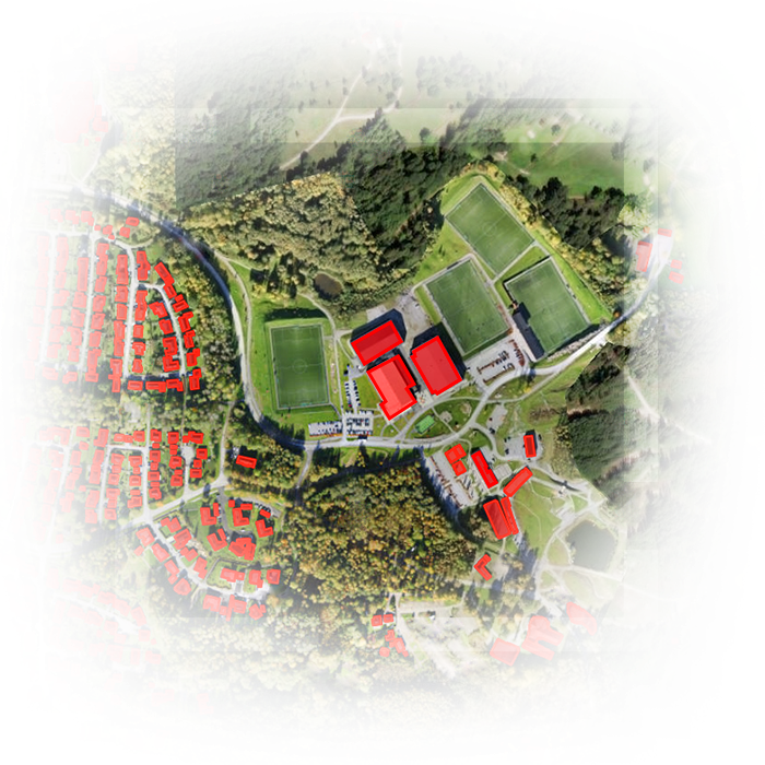 Satellite image of land with extracted buildings colored red and green land and trees