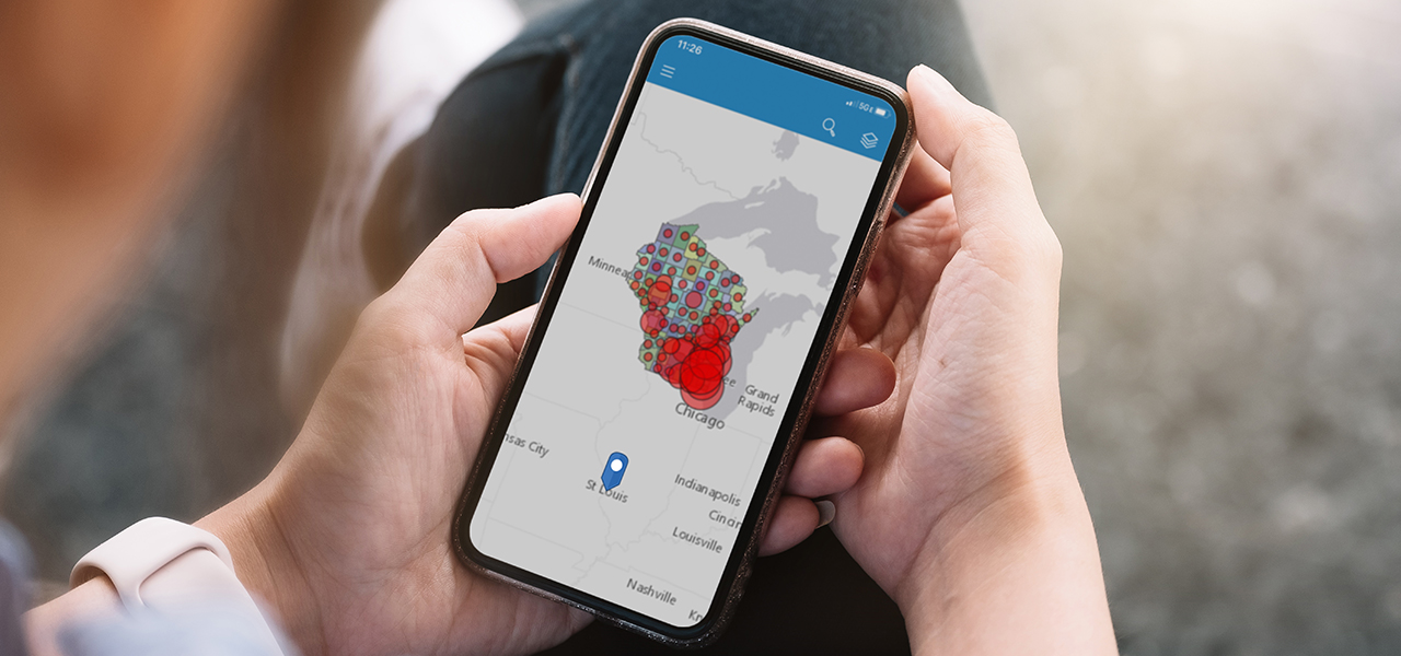 Two hands holding a cell phone that shows a map of Midwestern states
