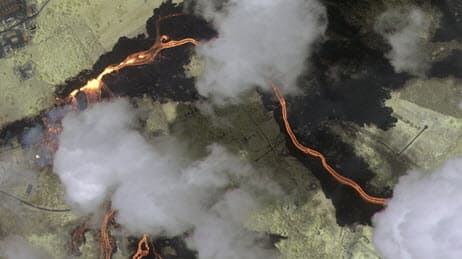 Aerial view of a lava flow with clouds above it