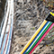 Fiber-optic cables laying in a shallow trench in the ground
