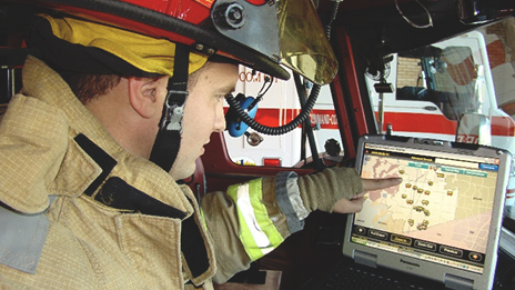 A firefighter using an interactive digital map on a screen inside a fire engine