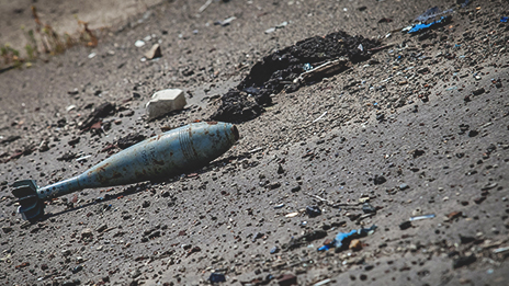 An explosive device exposed in a decimated, war-torn area.
