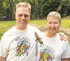 Kathryn Scott and Brian Hall, GIS analysts let a leaf-tailed gecko walk over their Esri t-shirts
