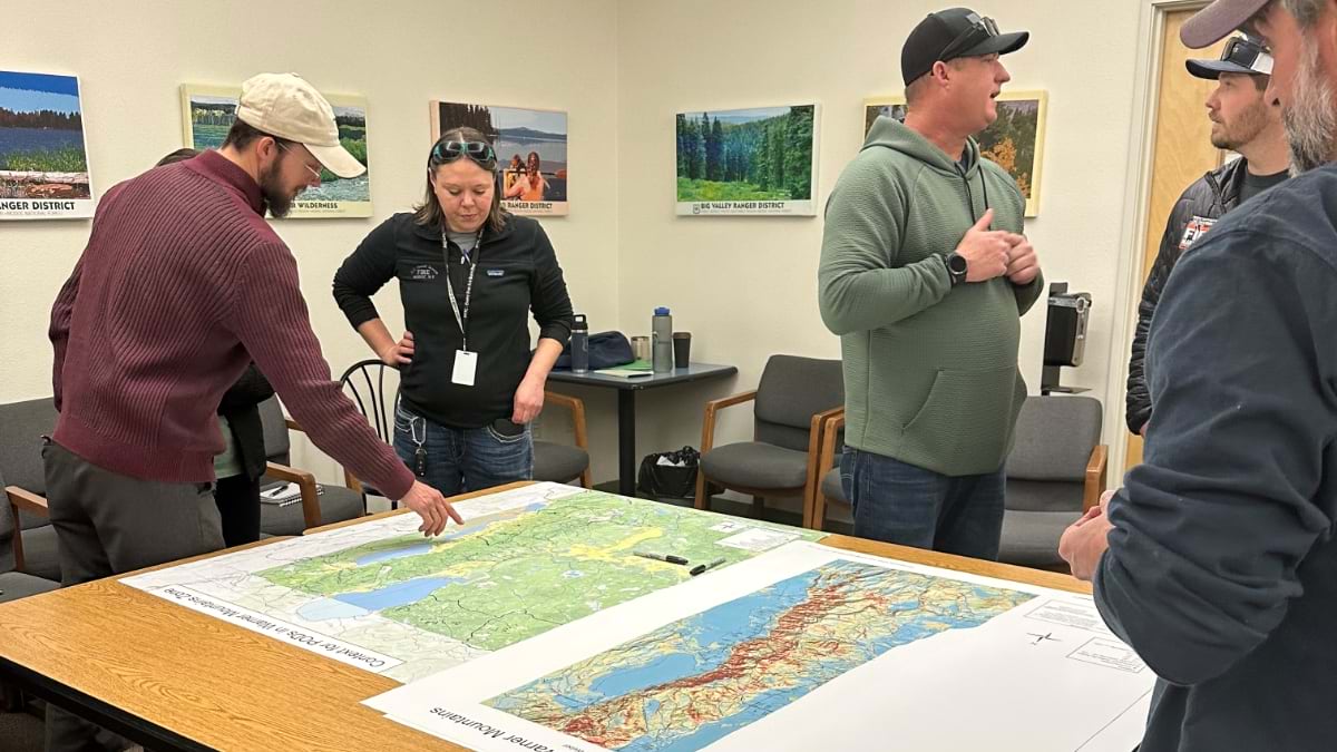 Staff pointing at a map and talking about where to eliminate fuel loads