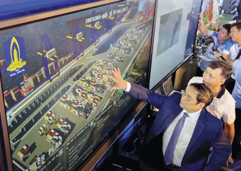 Two individuals look at a map of a waterfront port.