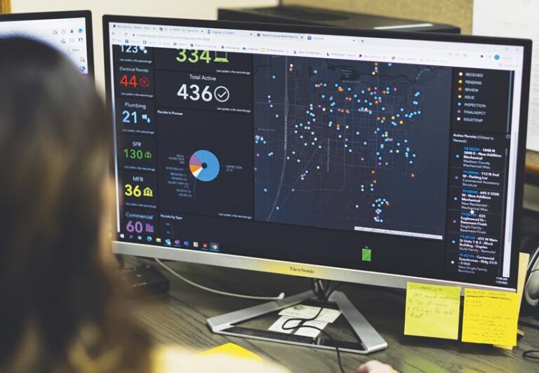 An individual faces a computer screen that shows a dashboard.