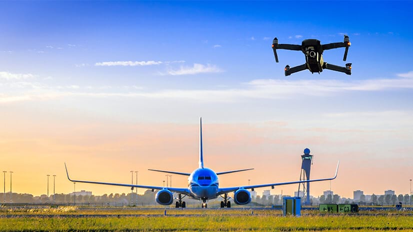 Drone inspections at an airport, with a commercial airplane in the background
