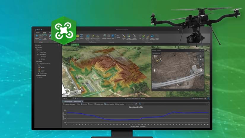 A drone flies in front of a computer screen displaying an aerial view