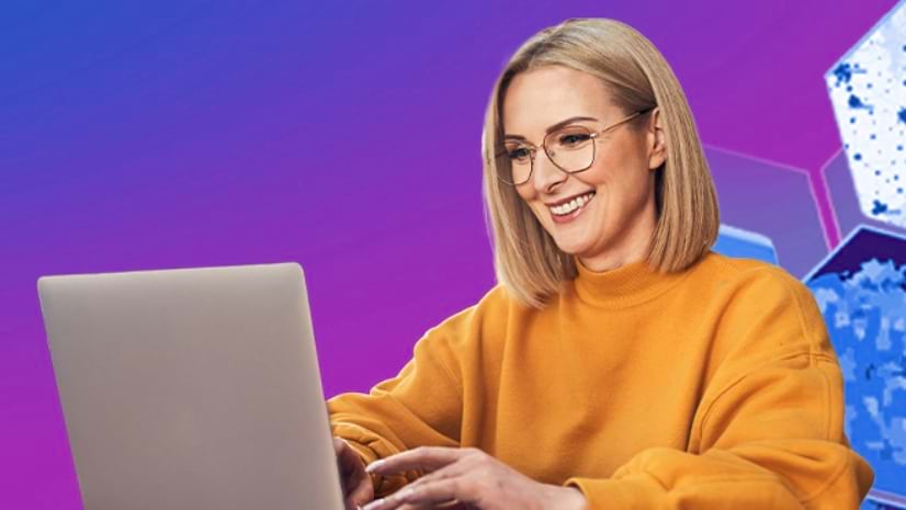 A person smiles at a laptop