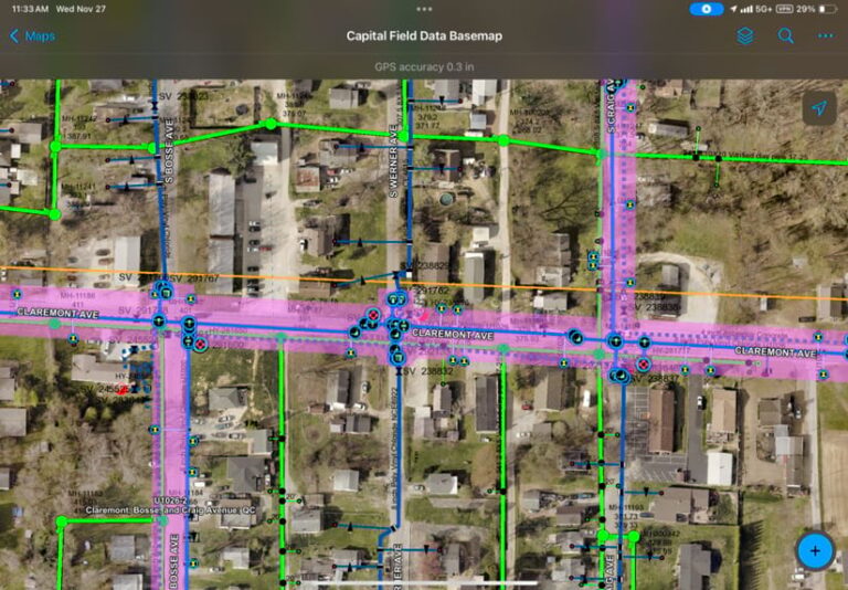 ArcGIS Field Maps screenshot displaying EWSU’s assets with blue and green lines over a satellite imagery basemap. The map also includes thicker pink transparent lines that follow major roads.