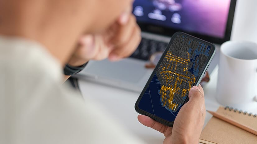 An over-the-shoulder look at a phone with a map signifying geospatial AI