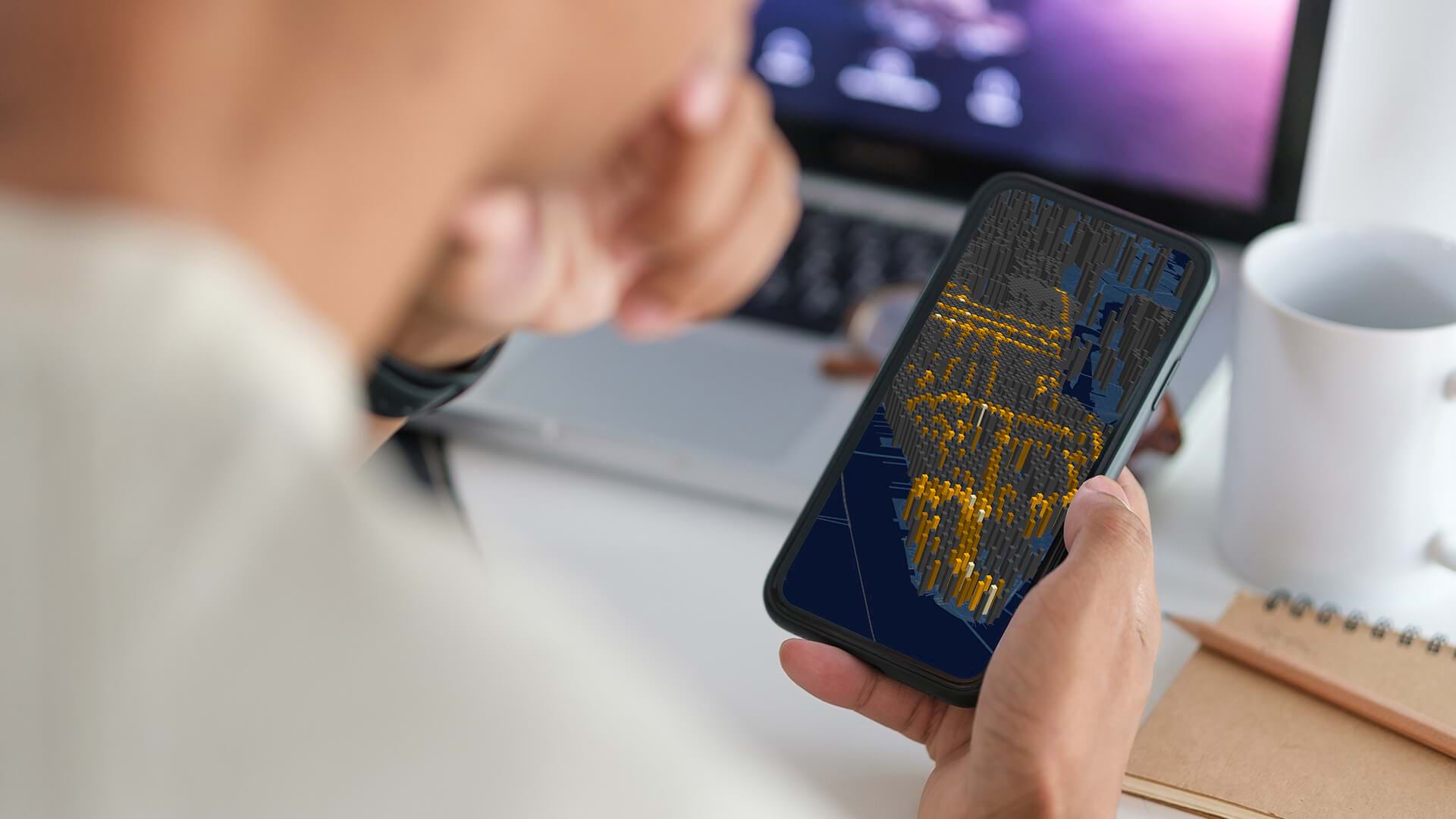 An over-the-shoulder look at a phone with a map representing geospatial AI