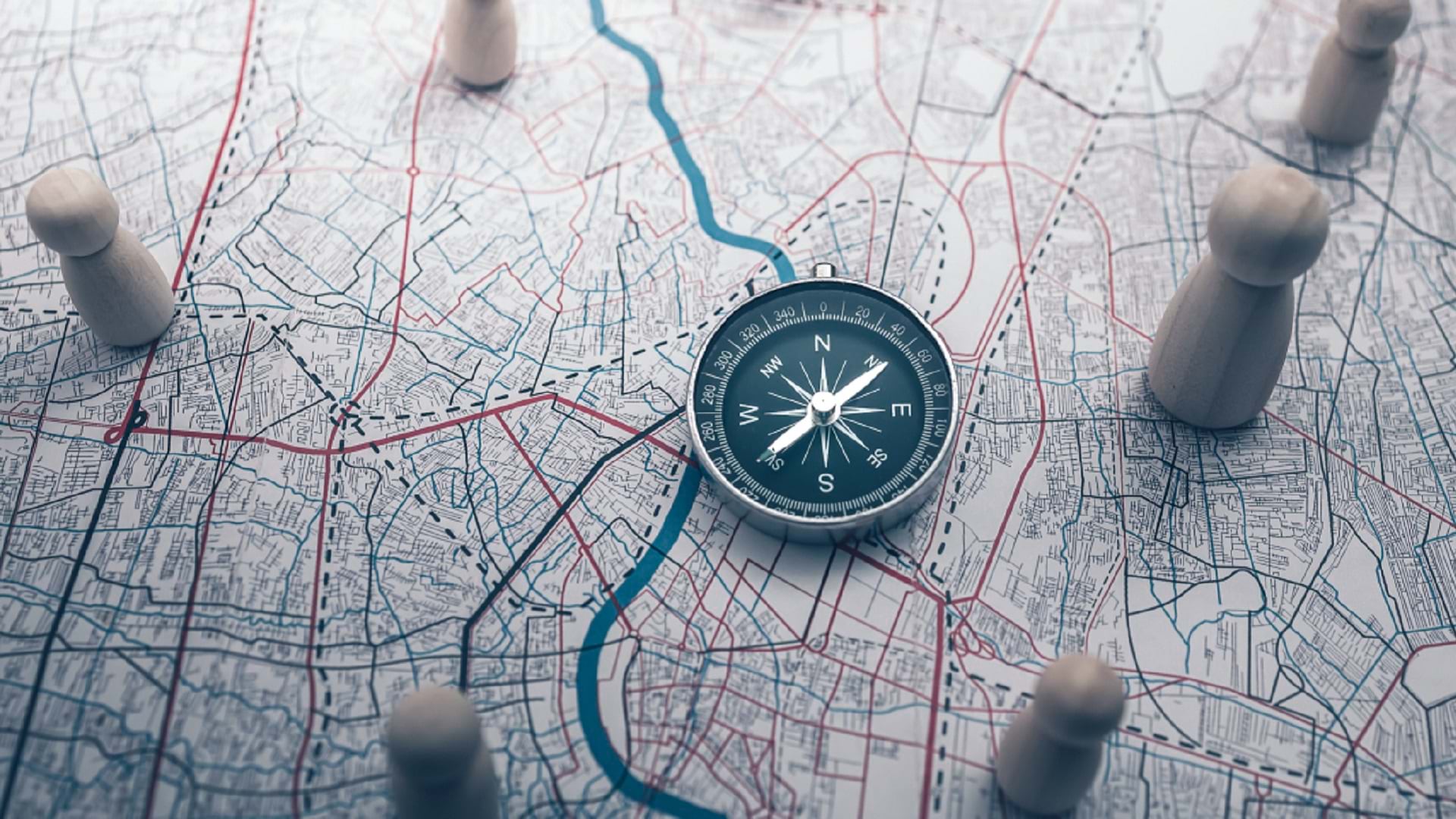 A compass, map, and figurines represent geospatial strategy
