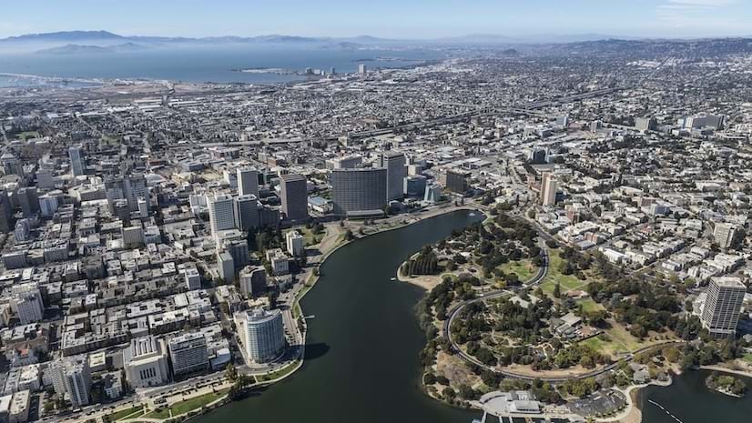 A view of a large, sprawling urban city with buildings and green land