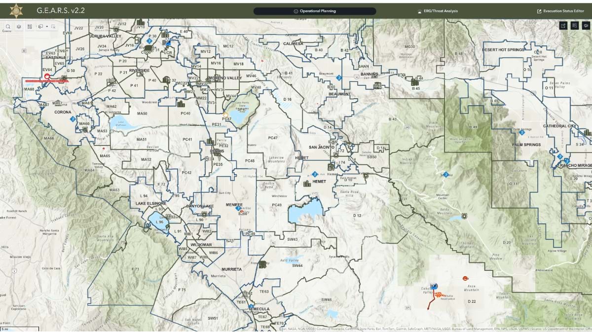 Screenshot of Riverside County's GEARS v2.2 emergency response platform showing a detailed topographic map with evacuation zones, municipal boundaries, and various operational planning tools across the county's diverse terrain from coastal areas to mountainous regions.