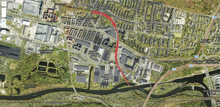 An aerial view of Siemensstadt, Berlin, with a red line drawn along Siemensbahn. The Spree River is visible at the bottom.