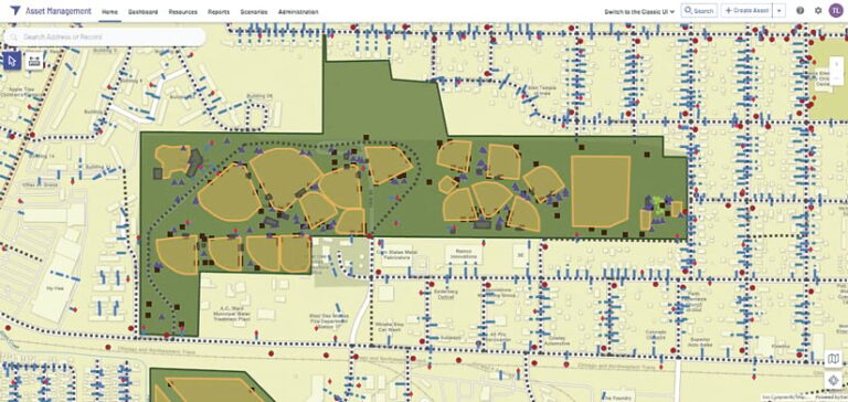 A screenshot of a web-based asset management system showing a map view. The map features buildings, roads, and a large park with ballfields. Icons represent assets within the mapped area. The interface includes a navigation bar and search function.