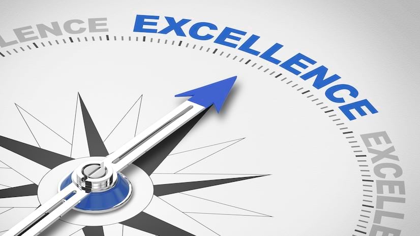 A vintage compass with a blue arrow pointing towards the word excellence