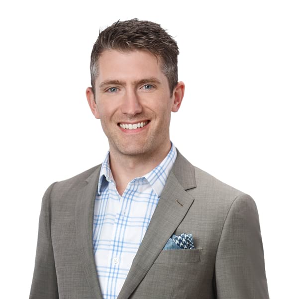 Headshot of a man in a tan blazer looking straight ahead.