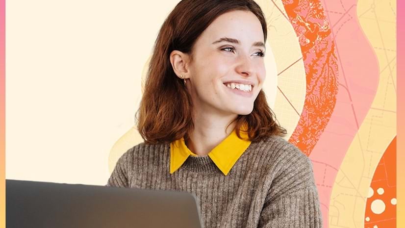 A smiling young woman working on a laptop