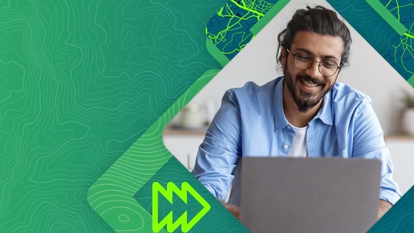 A smiling young man working on a laptop set against a green abstract background