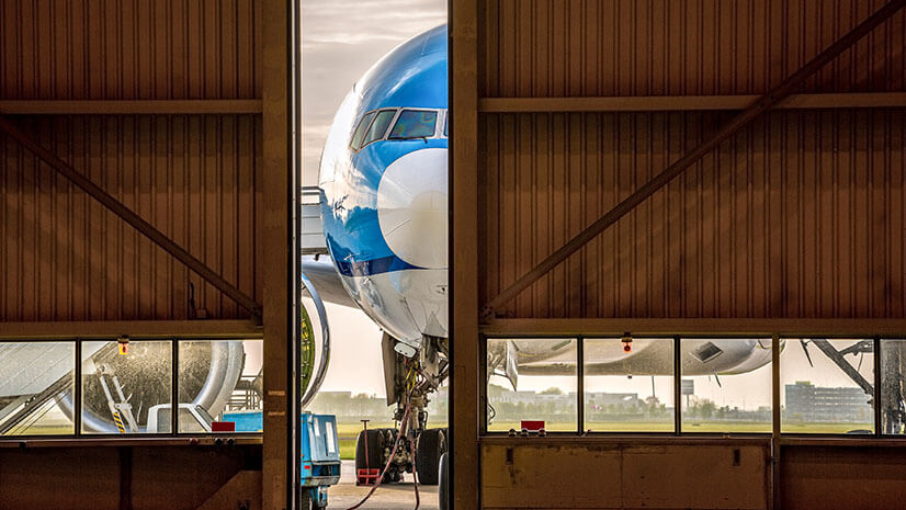 An airplane just outside a hangar signifies spare parts and maintenance