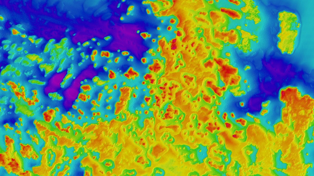 Vibrant bathymetric map showing complex reef structures with coral formations in orange and red, deeper channels in blue, across varied seafloor.