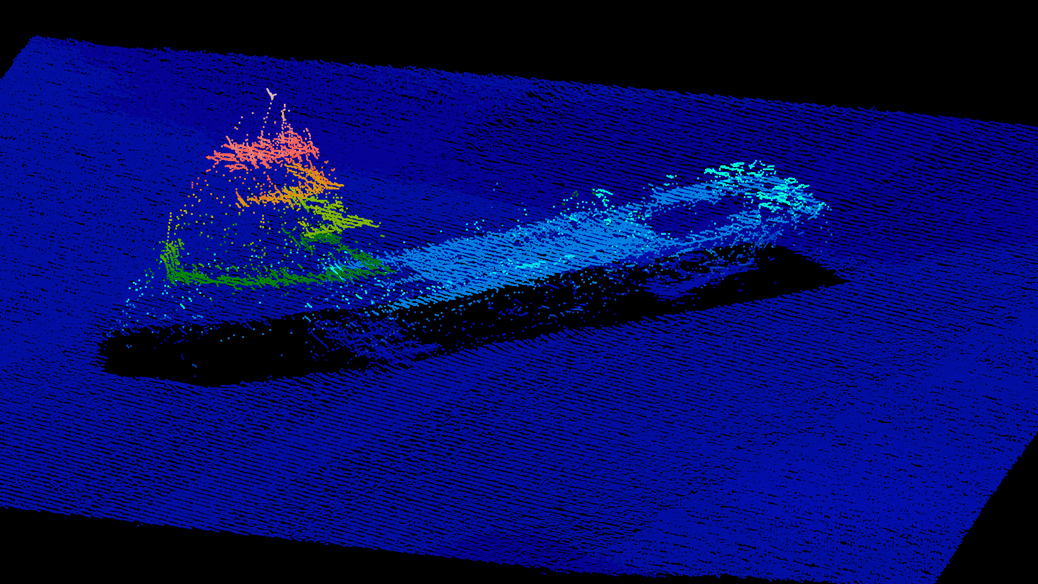 Three-dimensional sonar rendering of shipwreck on seafloor showing vessel structure rising from flat bottom, color-coded by elevation and relief.