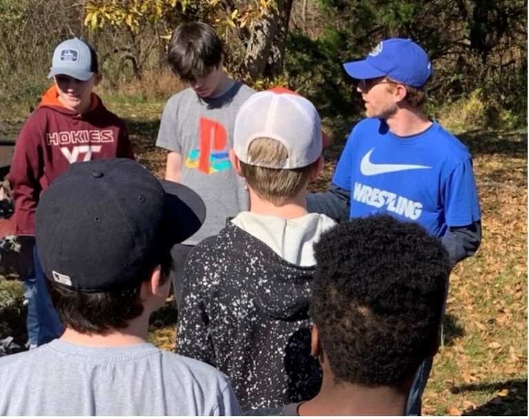 A group of young adults talking in the forest