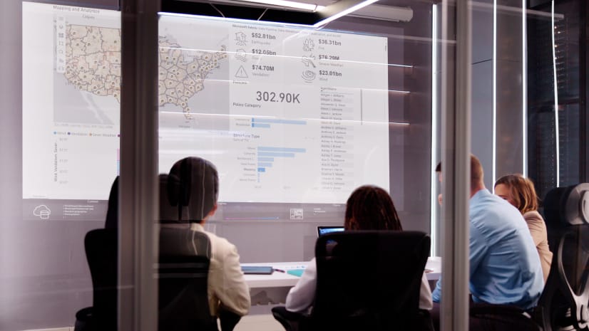 Business people view a no-code dashboard in a conference room