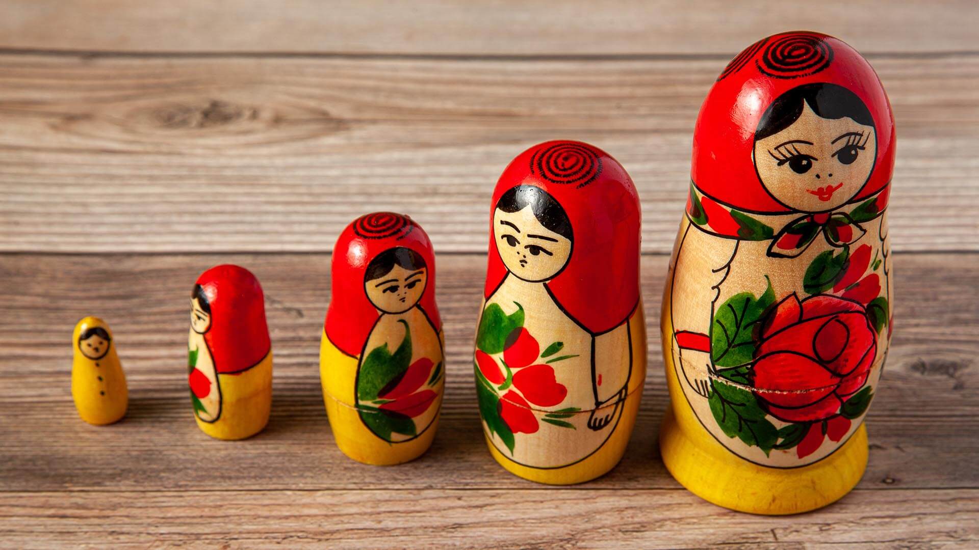 Colorful nesting dolls represent growth by acquisition