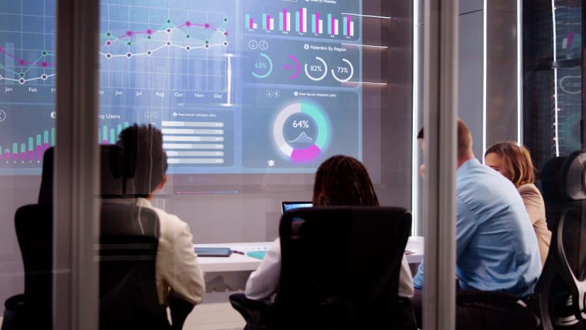 Business people view a no-code dashboard in a conference room