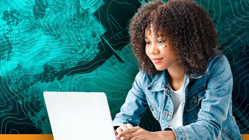 A smiling young woman typing on a laptop