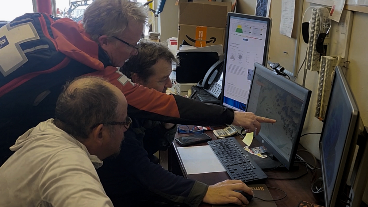 Ski patrol reviews avalanche data on the SmartMountain GIS system built on ArcGIS, tracking every explosive deployment and resulting slide across Jackson Hole's terrain. (Left to right: Wetherbee Dorshow of Earth Analytics Inc., Kevin Brazell, Mike Rheam)