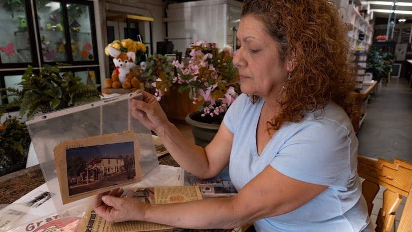 A woman holding up a black and white photograph