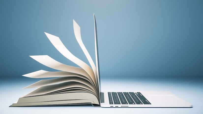 An open book next to laptop