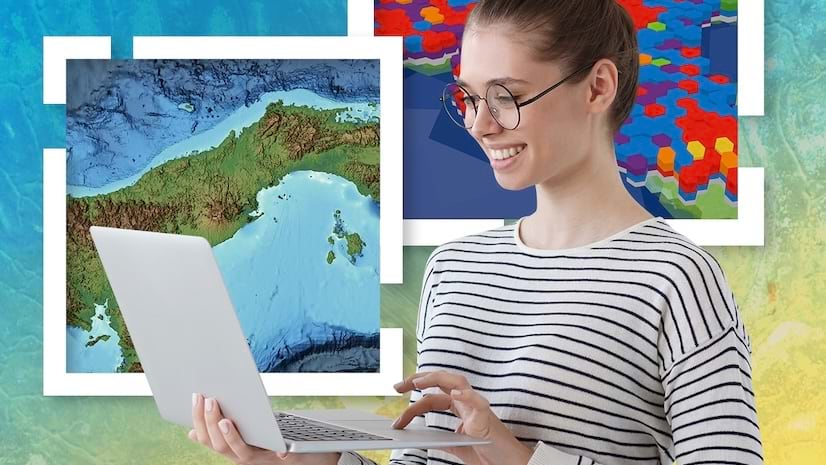 A smiling young woman looking at a laptop against abstract background of maps