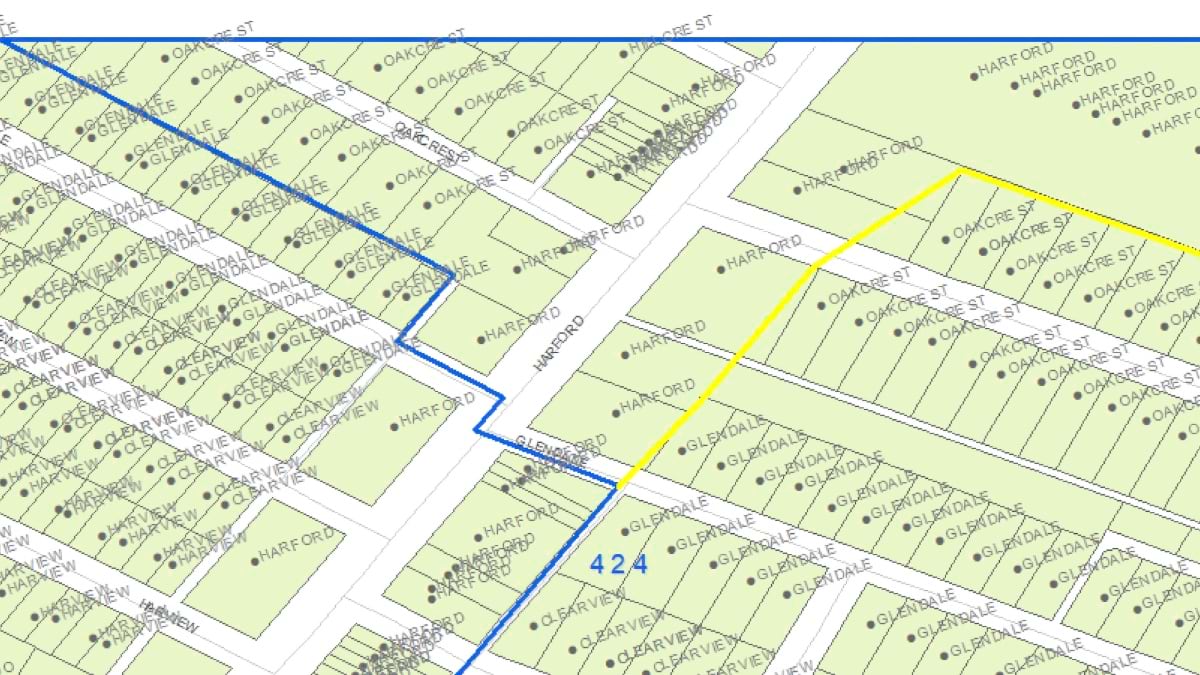 A parcel map near Harford Road shows a blue district boundary alongside a yellow line marking a proposed adjustment that was ultimately rejected to preserve workload balance.