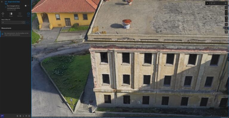 Three dimensional model of a large gray building with many windows in front of a smaller yellow residence with a shingled roof.