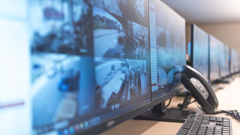 A bank of monitors and a phone signify corporate security operations