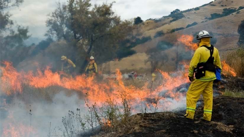 A group of firefighters fighting a bright orange blaze