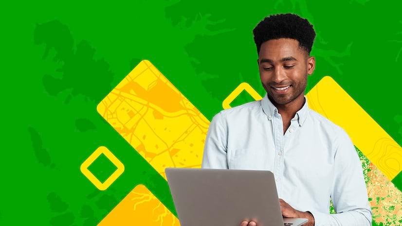 A smiling young man working on a laptop against a green and yellow abstract background