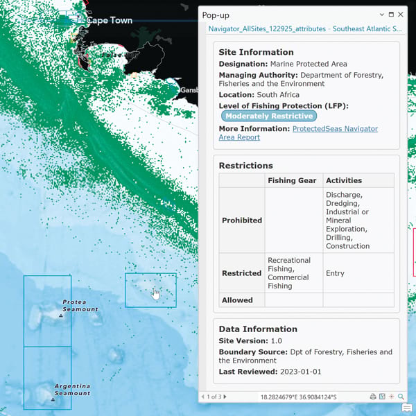 An ocean map with land colored black and swaths of white and green just off the coastline. A pop-up gives information about the site, including fishing restrictions.