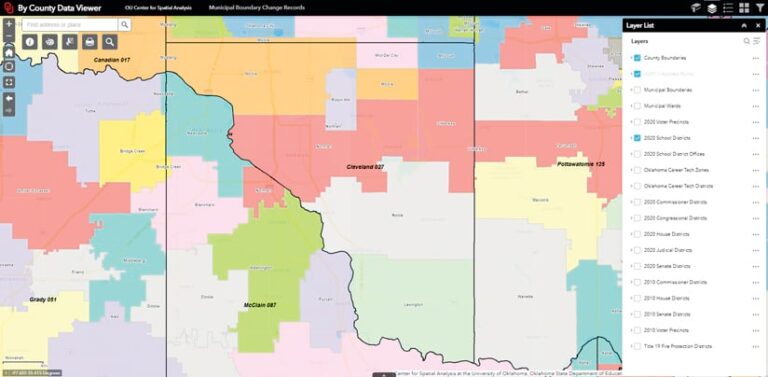 A screenshot of the "By County Data Viewer" interface displaying a color-coded map of Oklahoma's 2020 school districts. A "Layer List" panel on the right shows "County Boundaries" and "2020 School Districts" layers are selected and visible.