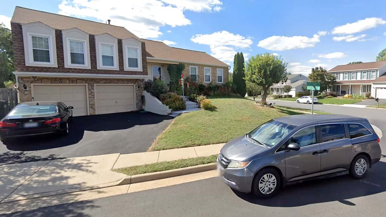 Two-story suburban home with attached garage on a residential street, daytime.