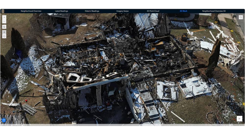 Screenshot of a 3D mesh model of a destroyed home shown in a GIS viewer with navigation tabs.