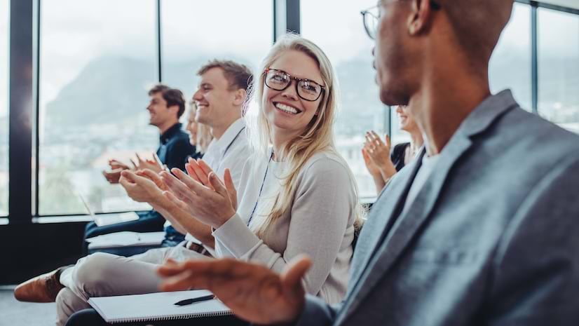 Group of men and women applauding after conference presentation