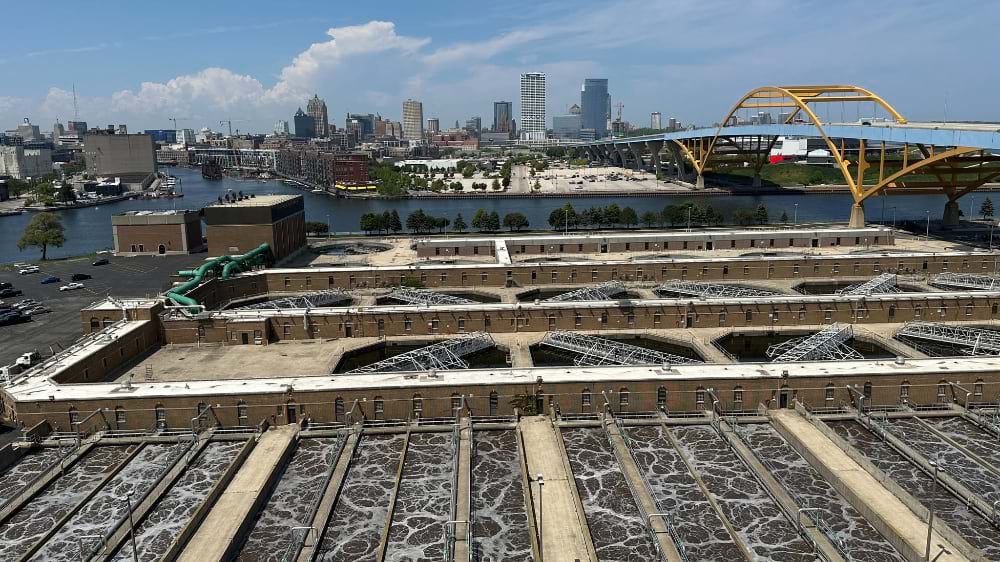 Aerial view of wastewater treatment aeration tanks with the Milwaukee skyline in the background.