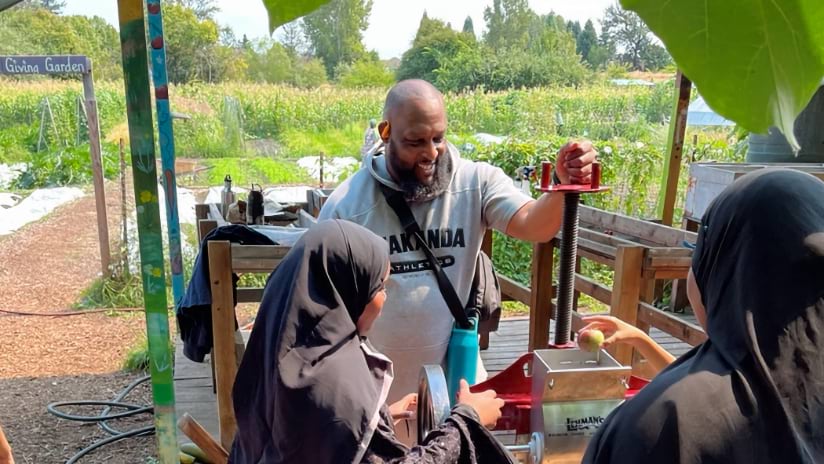 Community members press apples at Marra Farm's Solid Ground Giving Garden, a UFS site in a highest-equity-priority neighborhood in southwest Seattle.