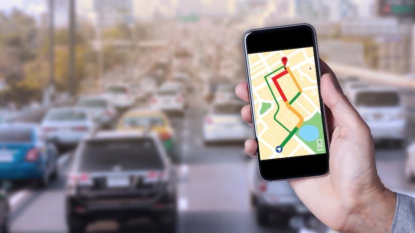 Hand of a person using map on smartphone app with traffic jam background